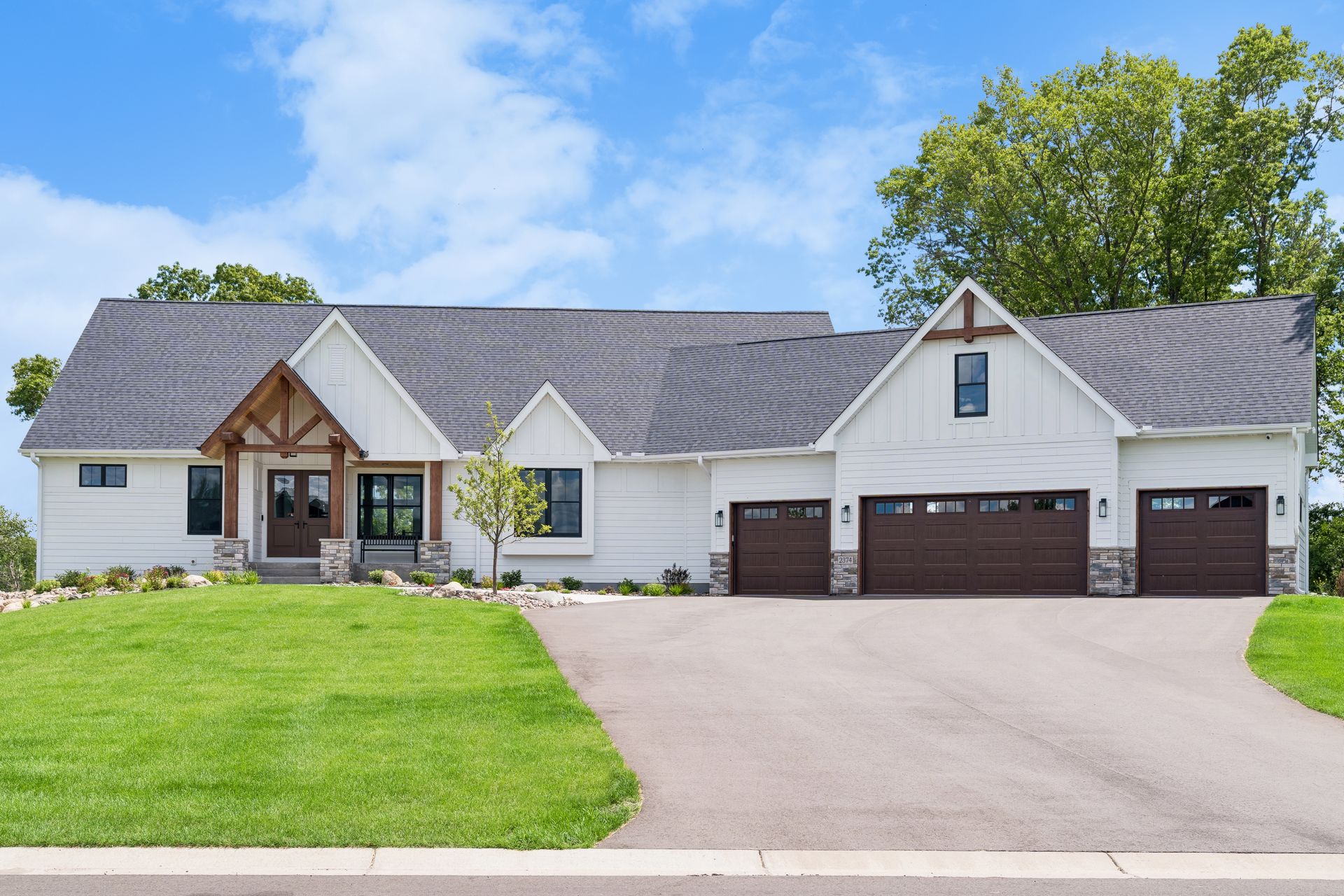 Street view of luxury custom home with oversized three car garage